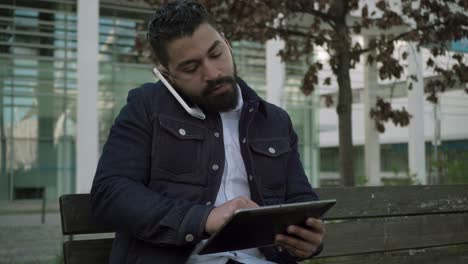 Konzentrierter-Mann-Nutzt-Smartphone-Und-Digitales-Tablet-Im-Freien